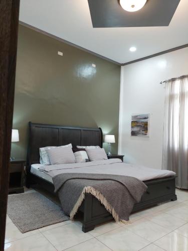 a bedroom with a large bed with white walls at Matteo's hus VILLA RENTAL in Zamboanguita