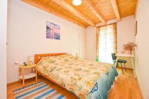 Schlafzimmer mit einem Bett, einem Schreibtisch und einem Fenster in der Unterkunft Apartment Fjaka in Žman