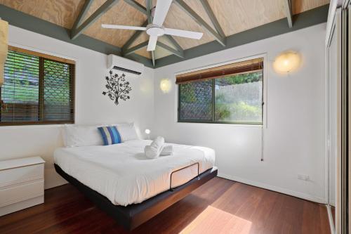 une chambre avec un lit avec un ventilateur de plafond dans l'établissement MAIN STAY - 100m to patrolled beach, pool, wifi, close to cafes, à Point Lookout