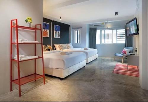 a large bedroom with two beds and a television at Bella Ciao in Jomtien Beach