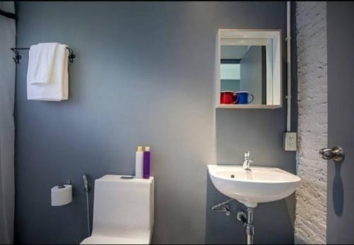 La salle de bains est pourvue d'un lavabo, de toilettes et d'un miroir. dans l'établissement Bella Ciao, à Jomtien Beach