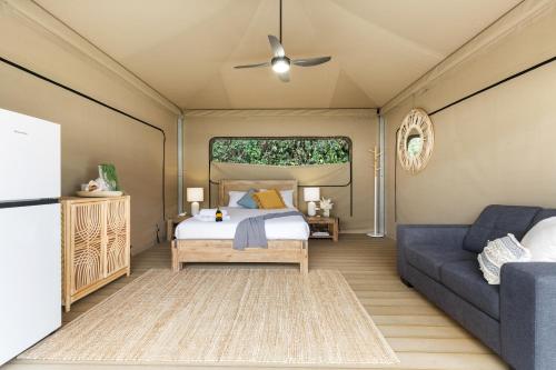 a bedroom with a bed and a couch at Poinciana at Cooee Bay in Yeppoon