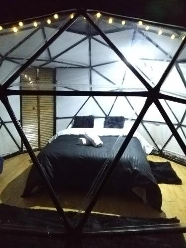 a bedroom with a large black bed in a tent at Glamping Wayra in Guatavita