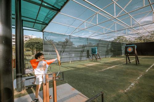 Um homem a segurar um arco num campo de ténis. em Shangri-La Sanya em Sanya