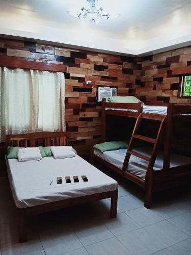 a room with two bunk beds and a chair at Woodland Inn in El Nido