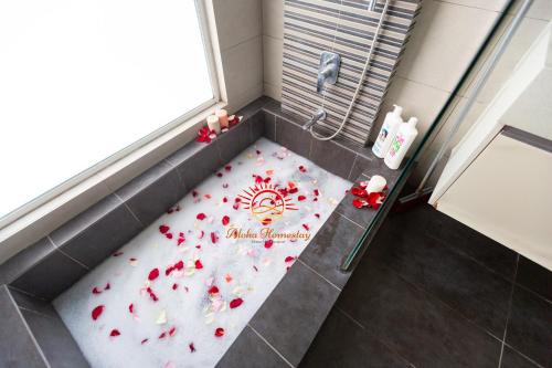 a shower with red flowers on the floor in a bathroom at SETAPAK CENTRAL KL-zeta suite by ALOHA in Kuala Lumpur