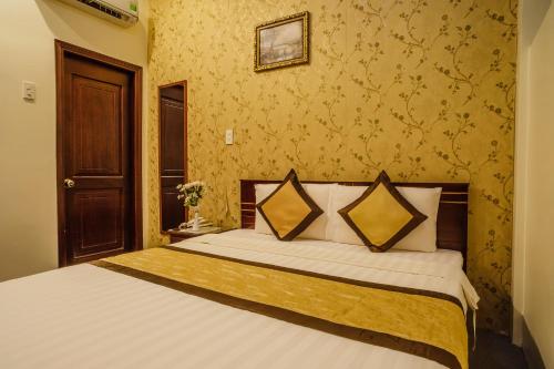 a bedroom with a large bed with yellow wallpaper at Dong Bao Hotel in Chau Doc