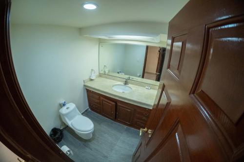 a bathroom with a sink and a toilet and a mirror at 17 Large room for two people in Torreón