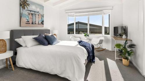 a white bedroom with a large bed and a window at Finding Remo in San Remo
