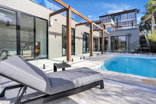 an image of a house with a swimming pool at Beachfront Escape - 6 bedroom, Pool & beach access in Merimbula