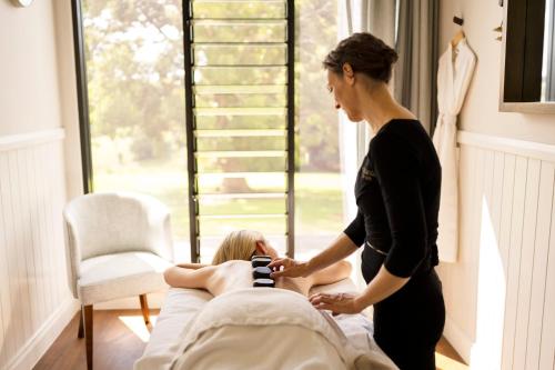 a woman standing next to a woman laying in a bed at Beechmont Estate in Beechmont