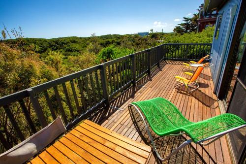 a deck with a bench and a chair on it at Retro Dunes Venus Bay - WiFi, Netflix, BBQ, linens, pets OK in Venus Bay