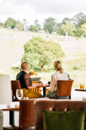 duas mulheres sentadas numa mesa num restaurante em Beechmont Estate em Beechmont