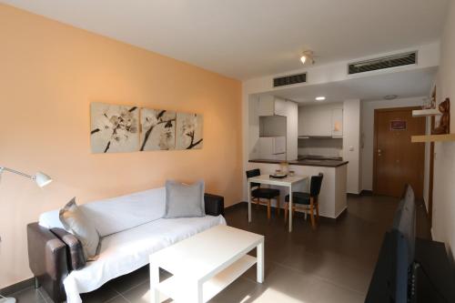 a living room with a white couch and a kitchen at Aguilas Residencial El Cedro BIF2 in Águilas
