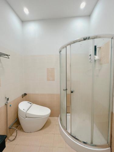 een badkamer met een toilet en een glazen douche bij HNK's Homestay Quy Nhơn in Quy Nhon