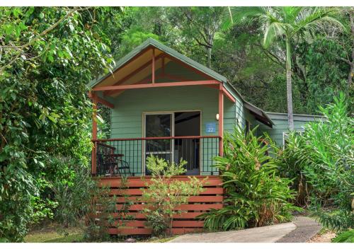 a small green and orange house with a porch at Discovery Parks - Airlie Beach in Airlie Beach