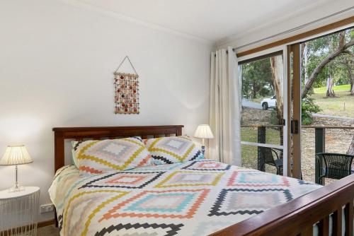 a bedroom with a bed and a balcony at Oceans Course in Lorne