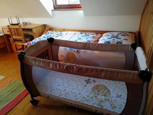 a small bed in a room with a table at Holidayhouse Chalupa Alžbetka in Važec