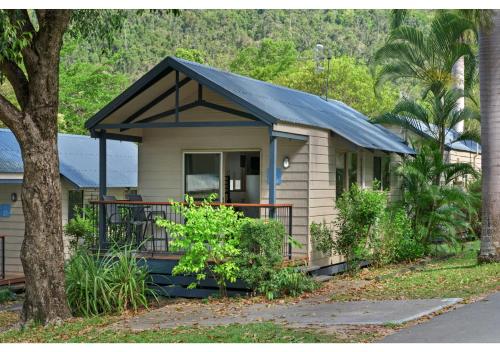 a small house with a black roof on a porch at Discovery Parks - Airlie Beach in Airlie Beach