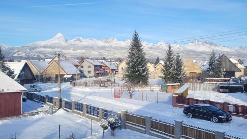 a snow covered town with mountains in the background at Holidayhouse Chalupa Alžbetka in Važec