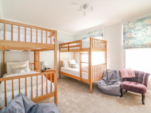 a bedroom with two bunk beds and a chair at Sailor's Abode in Weymouth
