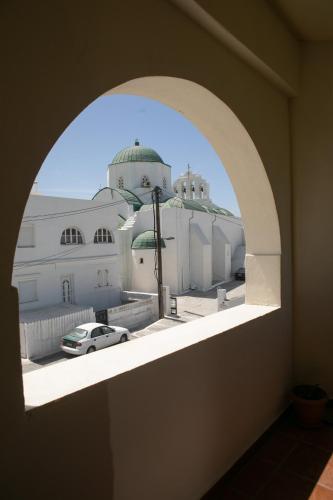an arched window with a view of a building at Apollon Hotel in Naxos Chora