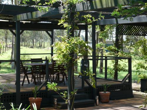 a pergola with a table and chairs and plants at 27 Rows on Hermitage in Pokolbin