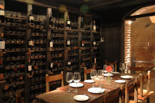 a table in a wine cellar with wine bottles at Huentala Hotel in Mendoza