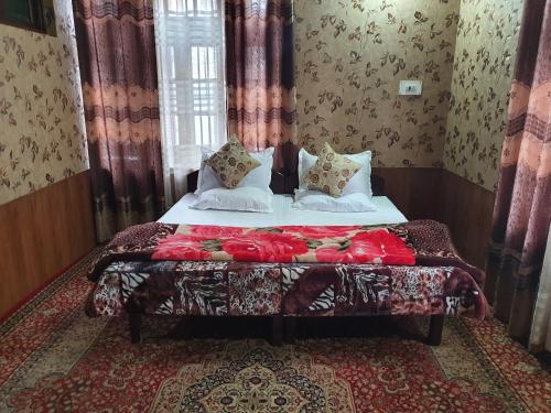 a bedroom with a bed with pillows on it at Hotel Wazir Palace in Srinagar