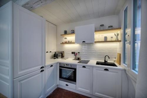 eine weiße Küche mit weißen Schränken und einem Waschbecken in der Unterkunft IMMOGROOM - Cosy - Renovated duplex - Close to the beach in Cannes