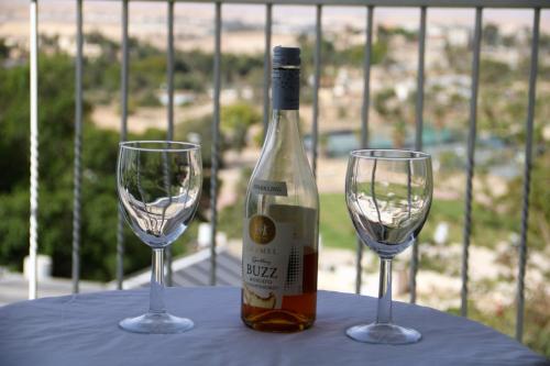 una botella de vino y dos copas de vino en una mesa en במיוחד בשבילך צימר ערד, en Arad