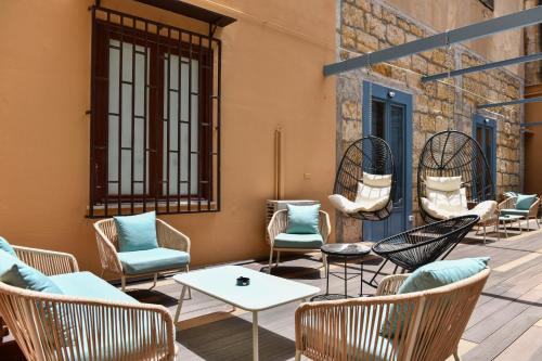 un patio avec des chaises et des tables dans un bâtiment dans l'établissement Mamamia al Teatro Biondo, à Palerme