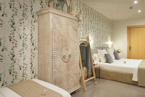 een slaapkamer met een bed en een grote houten kast bij Hotel Boutique Txanka Erreka PARKING INCLUIDO in Orio