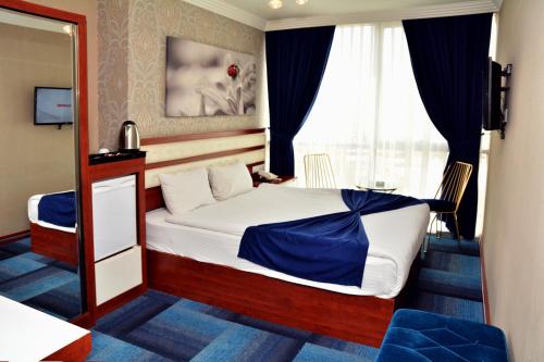 a small bedroom with a bed and a mirror at Business Grand Hotel in Ankara