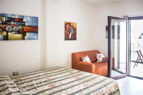 een slaapkamer met een bed en een stoel erin bij Appartamento Bocca Febbo in Orosei