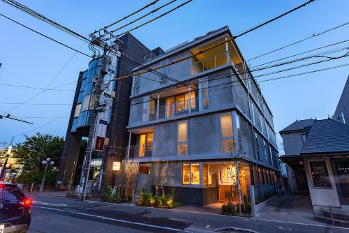 um edifício alto numa rua da cidade em plat hostel keikyu kamakura wave em Kamakura