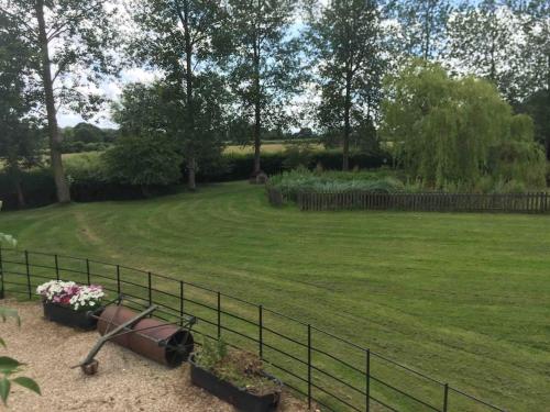 a garden with a fence and flowers in a field at The Annexe in Sturminster Newton