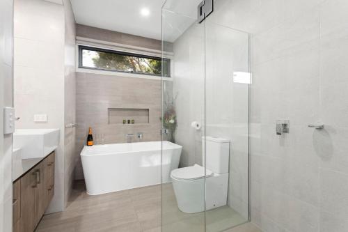 a bathroom with a toilet and a glass shower at Bay and Relax in Apollo Bay