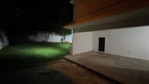 a dark room with a white wall and a green yard at CASA AZALEA in Guatemala