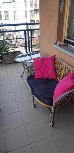 a chair with two pink pillows on a balcony at Nature in Kraków