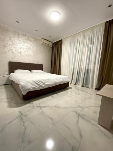 a bedroom with a bed and a marble floor at Central Apartament Mangalia in Mangalia