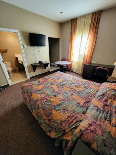 a hotel room with a bed and a television at Bonnyville Hotel in Bonnyville