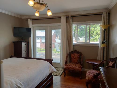 Schlafzimmer mit einem Bett, einem Stuhl und Fenstern in der Unterkunft Semi Centre House in White Rock