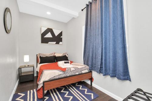 a bedroom with a bed and a blue curtain at La Casa Blanca-Rooftop Skyline with Gameroom in Houston