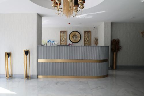 a lobby with a reception desk with a clock on the wall at Avion Suite Hotel in Antalya