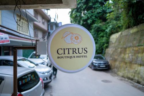 a sign on the side of a street with cars at Citrus Boutique Hotel in Gangtok