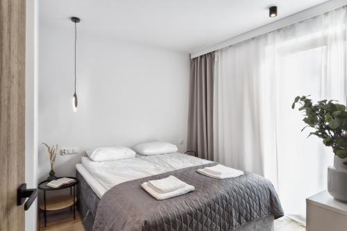 a bedroom with a bed with two towels on it at Willa La Calma in Łeba