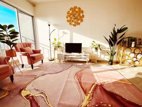 Sentrovue B Pink House في Bandar Puncak Alam: غرفة معيشة فيها تلفزيون وسجادة كبيرة