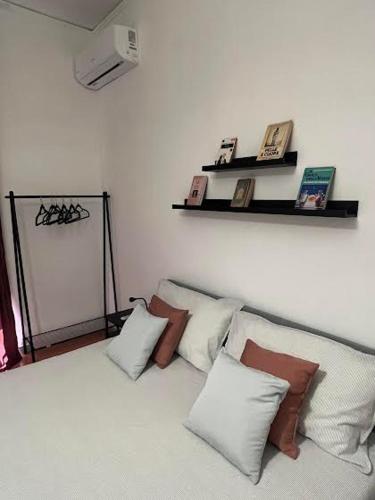 een kamer met vier kussens en een plank aan de muur bij Casa Castagna Dependance Pisapia in Pontecagnano