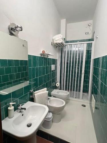 een groene en witte badkamer met een wastafel en toilet bij Casa Castagna Dependance Pisapia in Pontecagnano